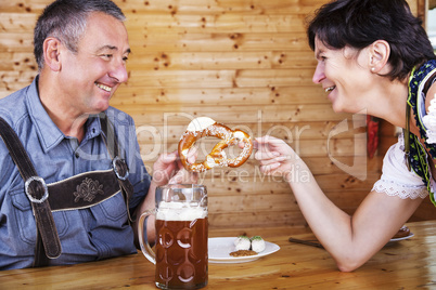 Man and woman with pretzel, beer and white sausage