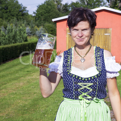 Woman in dirndl with beer mug at the Oktoberfest