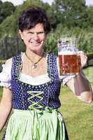 Woman in dirndl with beer mug at the Oktoberfest