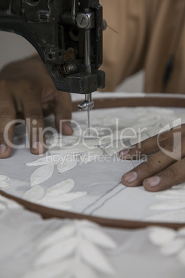 Tailor sewing on machine close up