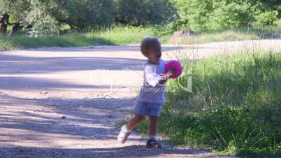 Little boy playing with ball in a summer park