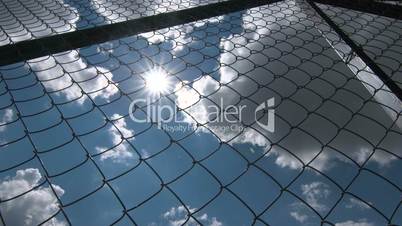 Sun shining through the chain link iron wire fencing