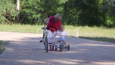 Senior woman with child learning to ride bicycle