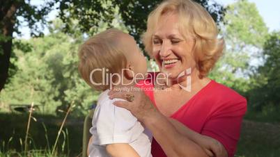 Happy grandmother with grandchild having fun in summer park  smiling
