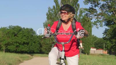Active senior woman cyclist on bicycle smiling