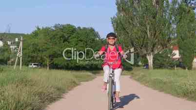 Active senior woman cyclist riding bicycle in the park