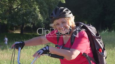 Smiling senior woman on bicycle looking at camera