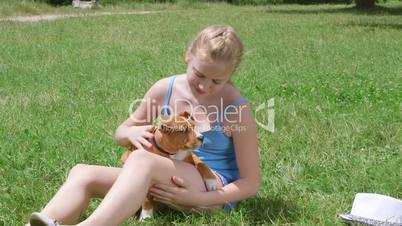 Little owner with american staffordshire terrier puppy dog on grass