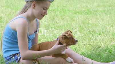 Child with puppy dog on green lawn in summer day