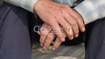 Senior man with cigarette gesticulating hand close-up