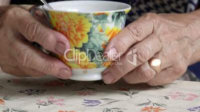 Senior woman hands holding cup of some drink