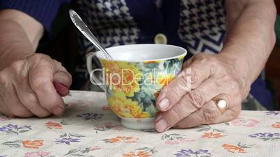 Senior woman hands with a cup of tea closeup