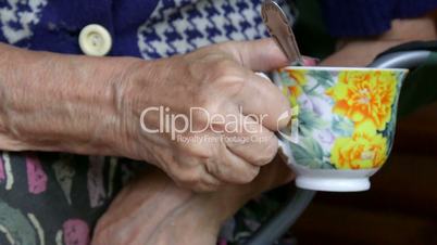 Senior woman hands holding cup of tea closeup