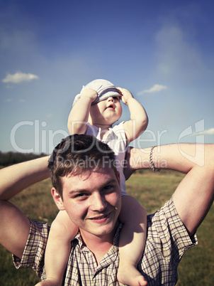 father holds a small child on his shoulders