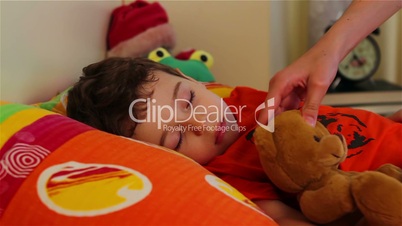 Cute little boy sleeping with his teddy bear