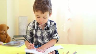 Little boy drawing his hand