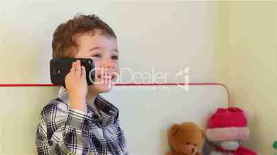 Smiling little boy talking on smartphone