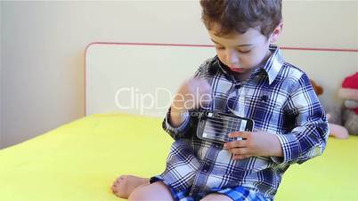 Little boy playing guitar on smartphone