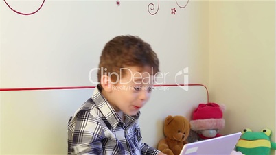 Surprised little boy watching laptop