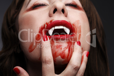 Female vampire licking blood