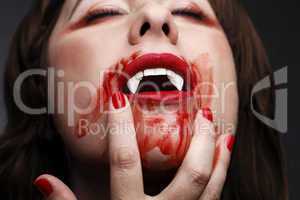 Female vampire licking blood