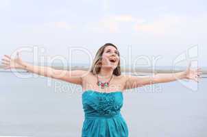 Happy woman with open arms looking at the sky