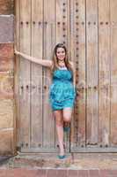 Beautiful woman in the dress in old wooden door