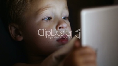 Boy with tablet PC before bedtime