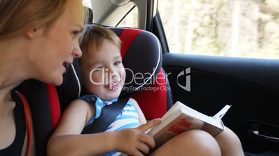 Mother and son with book traveling by car