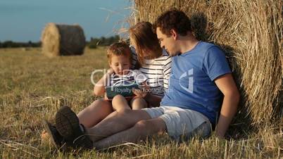 Parents and son in countryside with pad