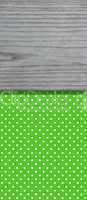 Grün gepunkteter Hintergrund mit grauem Holzbrett