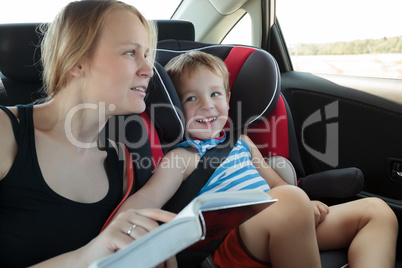 Mother reading a book to son in the car