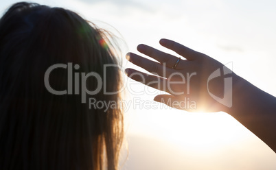 Woman hiding from the sun with hand