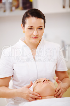 Facial treatment with massage therapist during seance at beauty spa