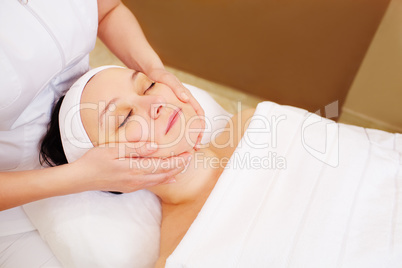 Woman taking facial treatments at beauty spa
