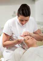 Cosmetician providing ultrasonic facial cleaning