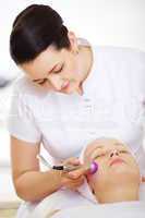 Cosmetician providing lifting procedure with special equipment
