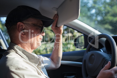 Senior driver hiding from the sun