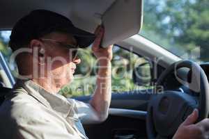 Senior driver hiding from the sun