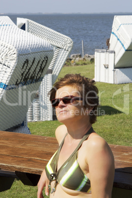 Woman and beach chairs by the sea