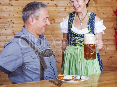 Man and woman in bavarian costume at the snack