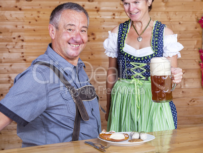 Man and woman in bavarian costume at the snack