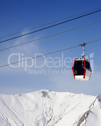 Gondola lift and snowy mountains