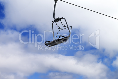 Chair-lift and blue sky with clouds