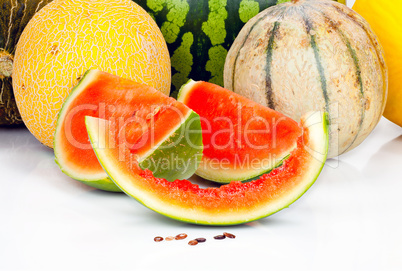 Aufgeschnittene Wassermelone liegt vor anderen Melonen