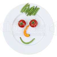 Gesicht aus Gemüse auf Teller freigestellt