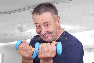 Elderly man with dumbbells during sport