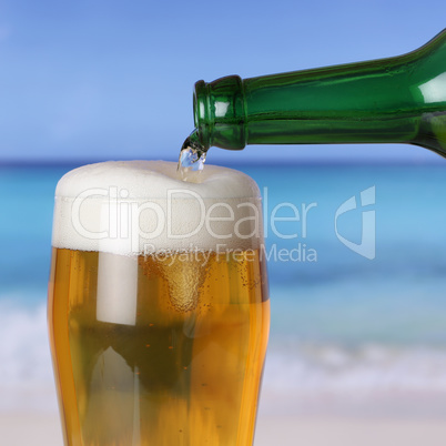 Bier eingießen aus Flasche ins Glas am Strand und Meer