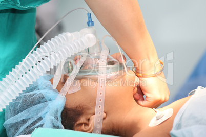 Nurse preparing the oxygen mask to an undentified patient for th