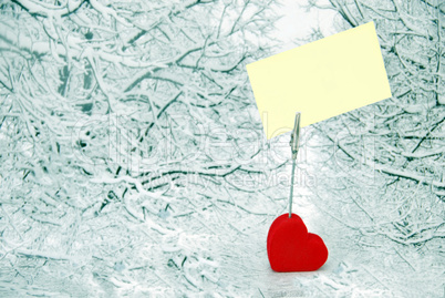 Heart holder with white paper over winter background